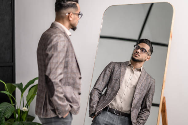 istock A good-looking young stylish man at the mirror 1391823586