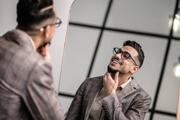 istock A good-looking young stylish man at the mirror 1391823589