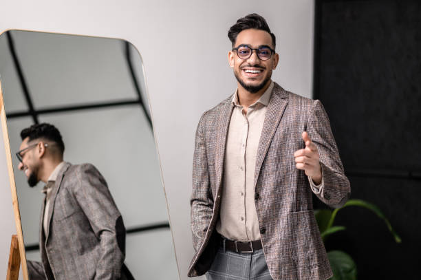 istock A good-looking young stylish man at the mirror 1391823595