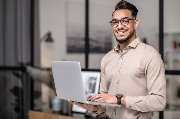 A young businessman with a laptop looking cotented stock photo