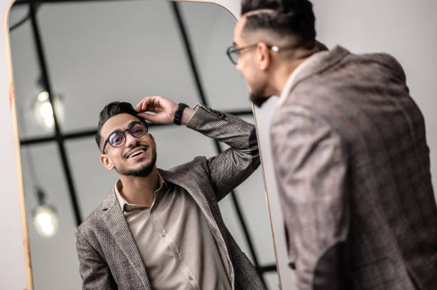 istock A good-looking young stylish man at the mirror 1391823627