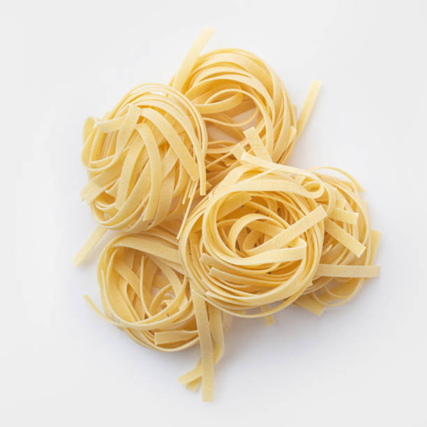 istock raw tagliatelle pasta with egg yolk in shell on white background 1391829306