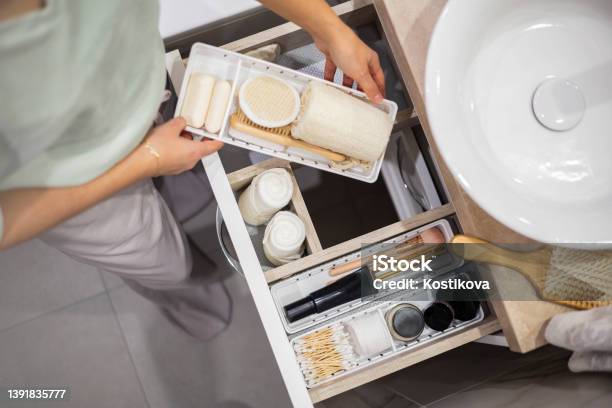 Top View Of Woman Hands Neatly Organizing Bathroom Amenities And Toiletries In Drawer In Bathroom Stock Photo - Download Image Now