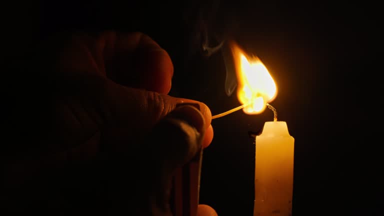 Match igniting candle flame in slow motion