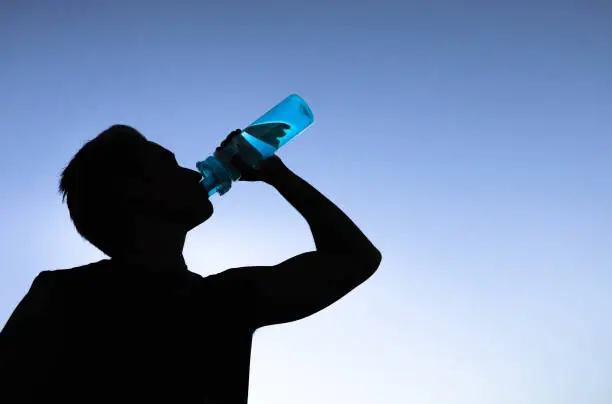 Photo of Man drinking water. Stay hydrated.
