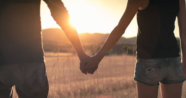istock Couple holding hands and watching beautiful sunset 1391844454