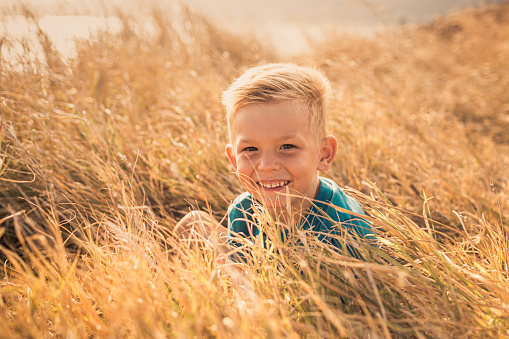 Little boy smiling in the field.