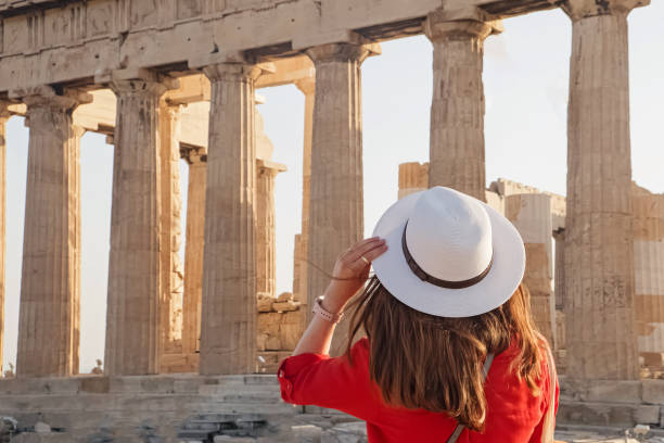 istock Woman in white hat looking on ancient Parthenon 1391845065