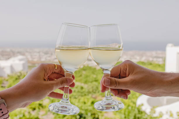 istock Two hands clinking with glasses of cold white wine 1391845072