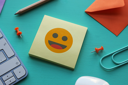 Smiling emoji on adhesive note paper