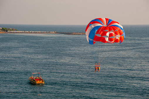 Antalya, Turkey - August 26, 2018 : Two people parasailing in Antalya with a speedboat