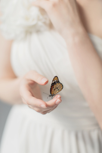 Girl with orange butterfly on hand. Beauty. Greek goddess. Purity and innocence