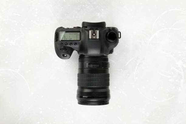 istock Big Black DSLR Digital Camera full frame sensor with lens on gray white cement background. 1391864707