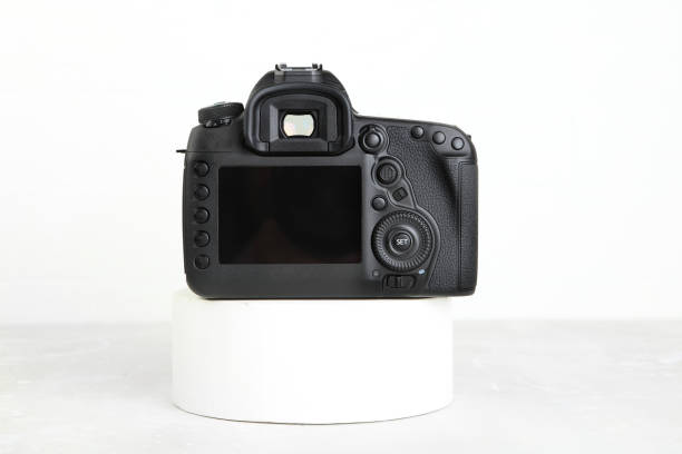 istock Big Black DSLR Digital Camera full frame sensor with lens on gray white cement background. 1391864709