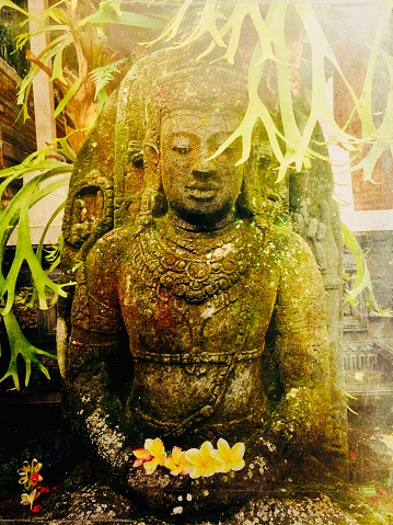 My original vertical closeup photo of an old stone Buddha sculpture in a tropical garden in Ubud, Bali has been transformed using the Mextures app to give a textured, antique feel to the image.