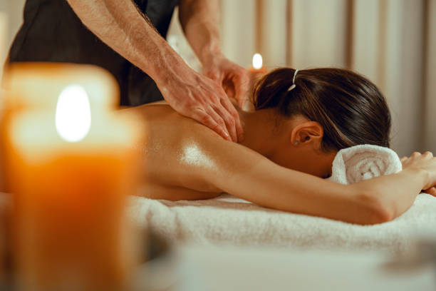 istock Woman relaxing while masseur doing spine back massage at beauty spa resort 1391865764