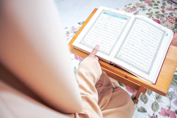 istock Muslim woman reading from the Quran. 1391866479
