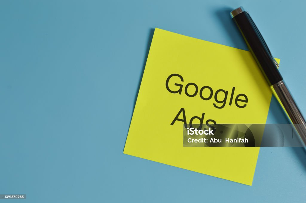 Top view of pen and memo note written with GOOGLE ADS. Advertisement Stock Photo