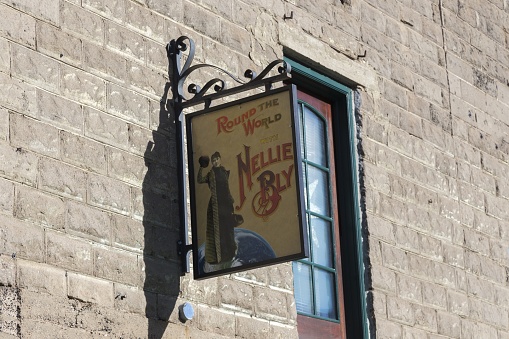 Jerome, Arizona, USA - December 1, 2021: Nellie Bly Sign on Brick Wall above Kaleidoscope Store, once Famous Jennie Bauters Brothel, on Main Street of Old Mining Town