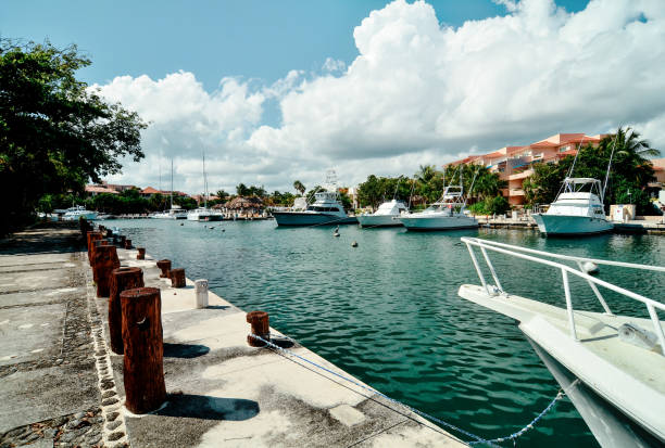 Yachts at berth in port. Mexico, Riviera Maya, resort town of Puerto Aventuras. Beautiful view of sea Bay and the yacht club yacht, yachting, boat, caribbean sea, riviera maya, mexico, puerto aventuras, sea, lagoon, river, fishing, adventure, america, aventura, bay, beach, beautiful, blue, coast, holiday, landscape, leisure, lifestyle, marina, maya, mayan, mexican, nature, ocean, outdoor, paradise, pier, port, puerto, recreation, resort, sail, sand, ship, sport, summer, tourism, travel, tropical, vacation, view, village, water, white puerto aventuras stock pictures, royalty-free photos & images