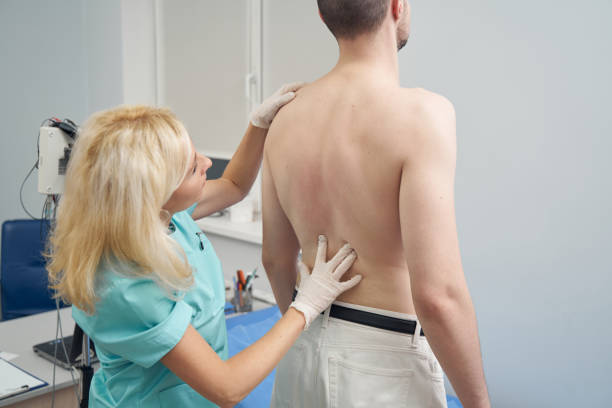 istock Female doctor examining man spine in office 1391878421