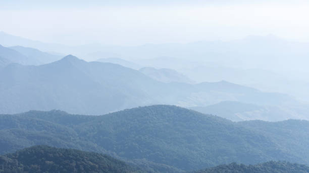 camada da cadeia de montanhas com neblina desbotada. - mist rock winter autumn - fotografias e filmes do acervo