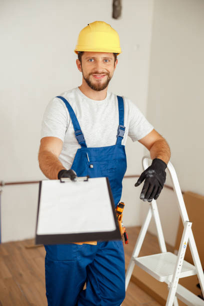 istock Smiling repairman extending his hand holding clipboard and smiling at camera while standing in new apartment 1391879544