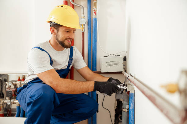 陽気な男性労働者、配管工はアパートに暖房システムを設置しながらパイプをチェックする - plumber thermostat repairing engineer ストックフォトと画像