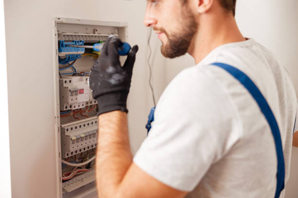 istock Electrical technician in uniform installing and connecting electrical equipment in a switchboard with fuses 1391879573