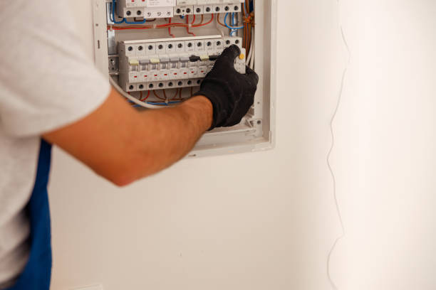 istock Hand of electrical technician checking fuses in a switchboard on the wall 1391879579