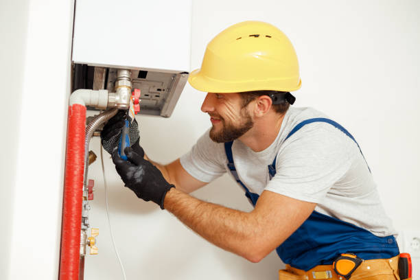 便利屋、ボイラーや給湯器を固定しながらドライバーを使う技術者、アパート内の暖房システムに取り組む側面図 - plumber thermostat repairing engineer ストックフォトと画像