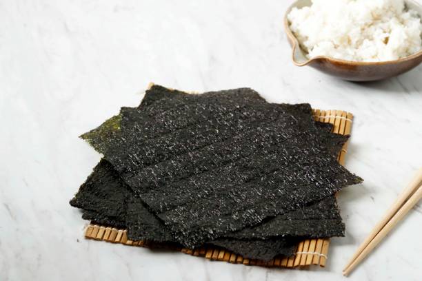 Selected Focus Dried Laver on White Plate, Copy Space for Text Selected Focus Dried Laver on White Table for Making Sushi or Gimbap, Copy Space for Text nori edible seaweed sheet stock pictures, royalty-free photos & images