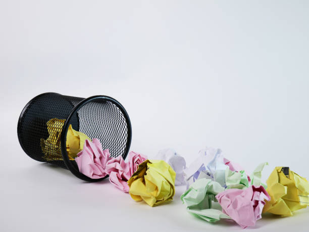 istock A small black basket made of round iron fell down. It is used to put the trash, documents that are not working and are overflowing to the outside. In the white background there is a copy space. 1391894620