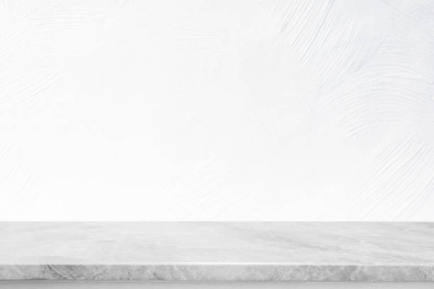 istock Empty white stone marble table top and blurred white wall in garden background - can used for display or montage your products. 1391897313