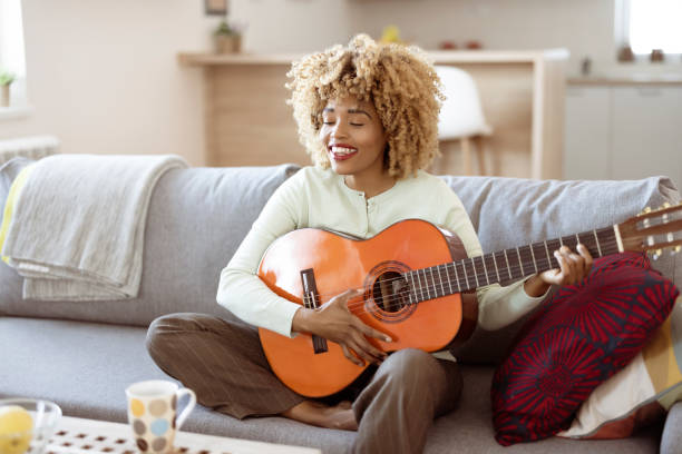 istock Woman Playing Acoustic Guitar at Home 1391903120