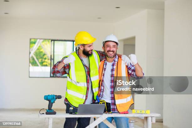 Handshake Electrician And Construction Engineer Man Team In Safety Uniform Working And Planing In Construction Site Stock Photo - Download Image Now