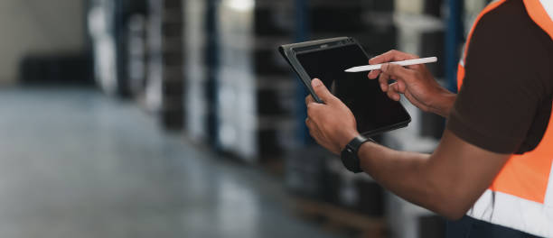istock Panoramic close up hand of smart engineer man warehouse management system.Worker hands holding tablet with pen on blurred warehouse as background. logistic, Import export concept. 1391903730
