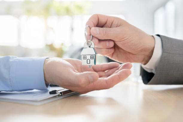 Real estate agent property Real Estate Agent or landlord giving house keys stock photo