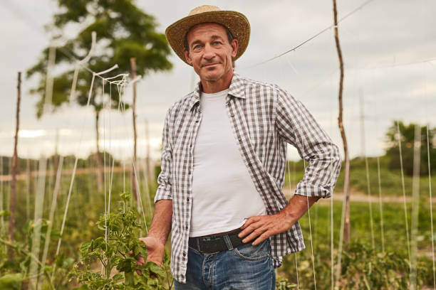 istock Happy farmer standing on green plantation 1391908391