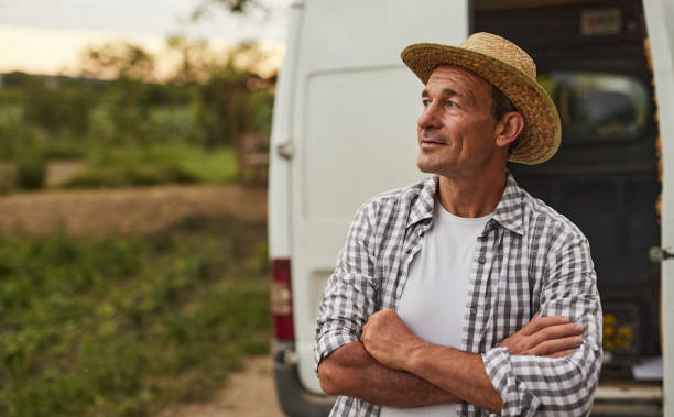 istock Confident mature farmer standing near van 1391908484