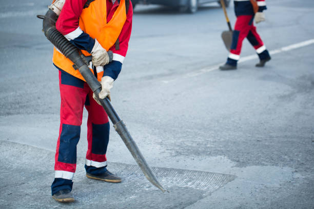 istock Worker with leaf-blower, cleaning out the dust for better asphalt adhesion, during tram track renewal works. 1391909598