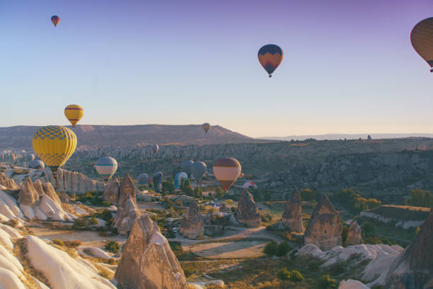 Hot air balloons flying over Cappadocia landscape