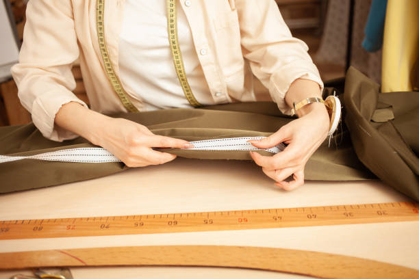 istock seamstress in atelier, portrait at work. Table with fabric and sewing tools, indoors. 1391910184