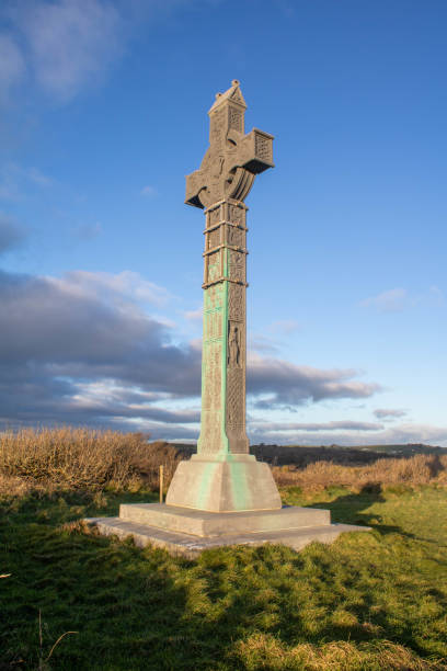 кельтский крест смотрит над небом на закате, западный корк ирландия. - celtic cross cross shape blue vertical стоковые фото и изображения