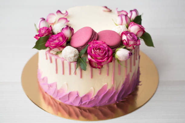 istock Cake with roses, sweets and lilac macaroons 1391912622