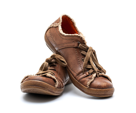 A pair of old weathered baseball cleats, warmly lit on an old wood background. Tinted slightly to add to the nostalgic feel.