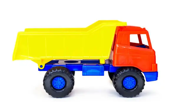 Photo of colorful plastic toy tipper dumper truck, isolated (global altered)