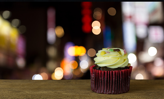 Cupcake on wooden table with night light background