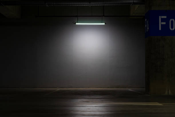 istock Empty parking lot with overhead dim light, underground parking garage. 1391929293