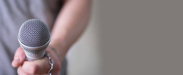 istock A man holds a microphone in his hand with room to copy. 1391932101